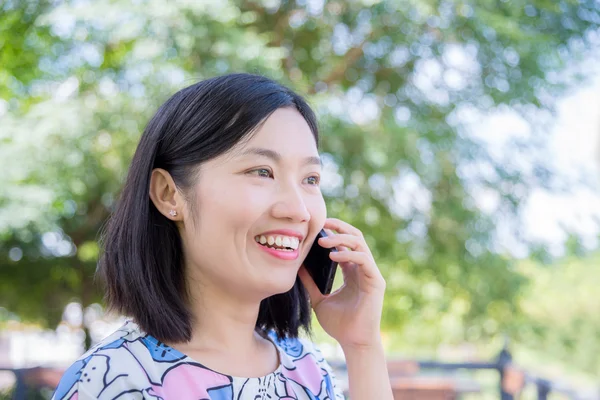 Frau unterhält sich mit Freundin per Smartphone — Stockfoto