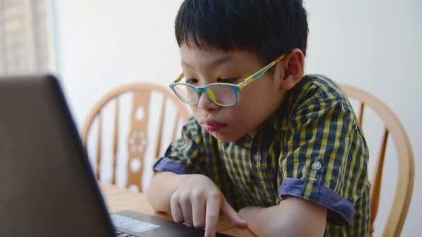 Niño jugando juegos en el ordenador portátil . — Vídeos de Stock