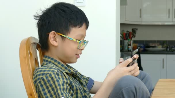 Мальчик играет в игры на смартфоне — стоковое видео