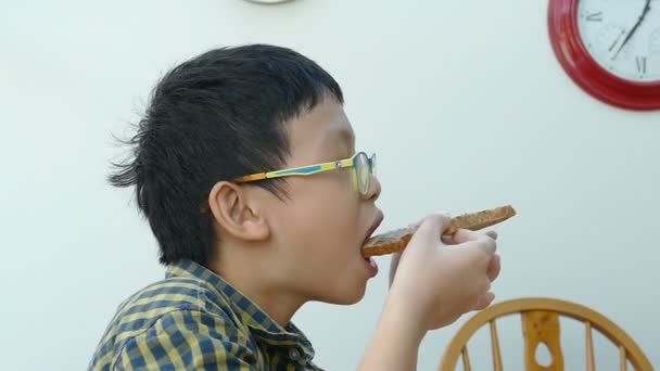 Niño comiendo tostadas en casa, cámara lenta — Vídeos de Stock