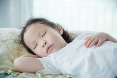 Kız yatakta uyuyor. 