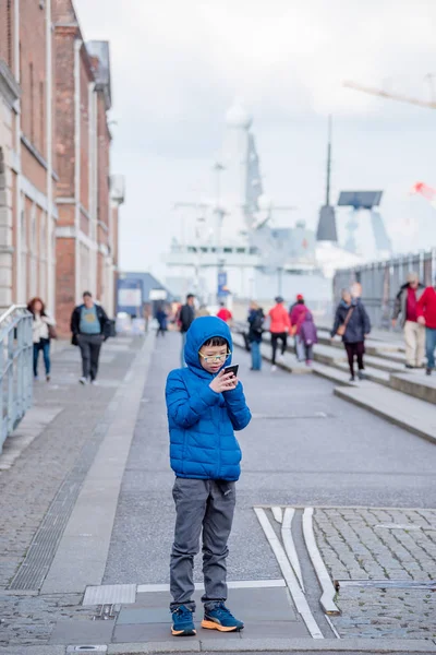 Niño usando el teléfono inteligente en la calle — Foto de Stock