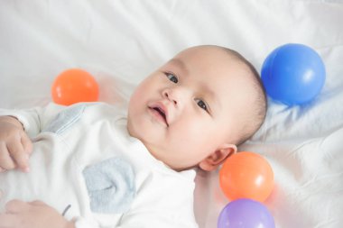 Küçük çocuk topla yatakta yatarken