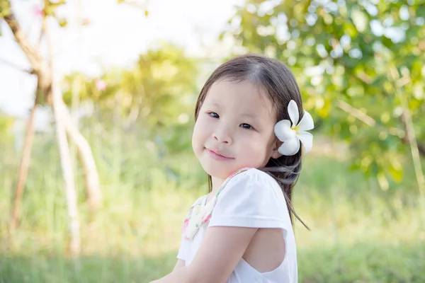 Fille avec fleur sur les cheveux dans le jardin — Photo