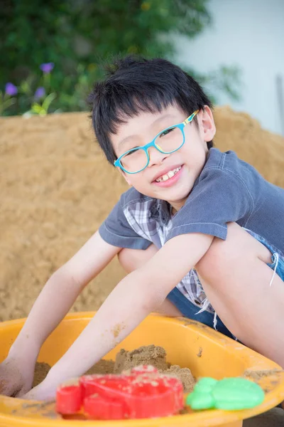 Jongen spelen zand in de zandbak — Stockfoto
