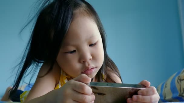 Menina assistindo desenhos animados via telefone inteligente — Vídeo de Stock