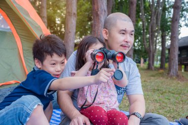 Küçük kız ailesiyle birlikte kamp arasında Binoküler arıyor