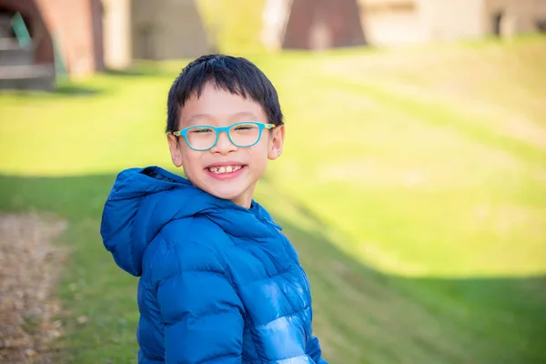 Ragazzo sorridente al campo di erba — Foto Stock