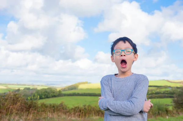 Boy yawning at field in morning — Stock Photo, Image
