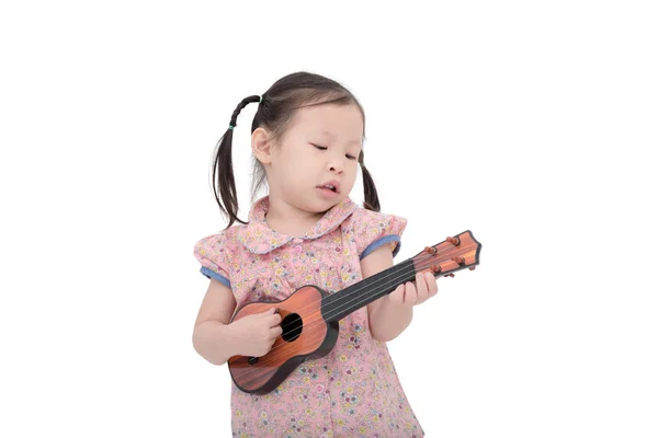 Bambina giocando giocattolo di chitarra su bianco — Foto Stock