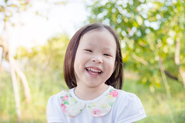 Küçük kız parkta gülümseyen — Stok fotoğraf