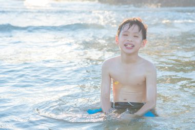 Genç Asyalı çocuk kumsalda oynarken