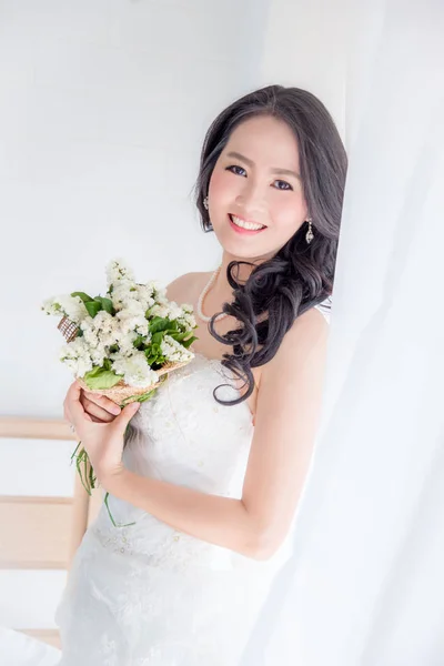 美丽的亚洲新娘在房间里捧着鲜花花束 — 图库照片