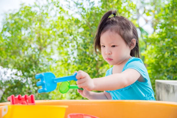 小亚洲女孩在沙子箱子里玩沙子 — 图库照片