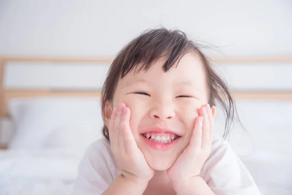 Ragazzina sorridente sul letto — Foto Stock