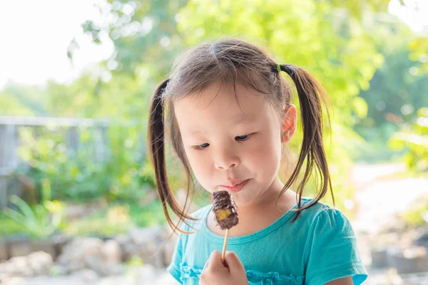 Little girl eating chocolate — Stock Photo, Image