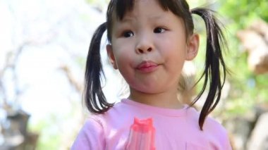 Küçük Asyalı kız parkta dondurma yeme 