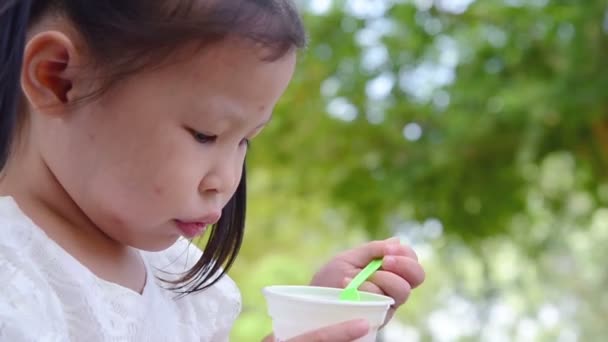 Μικρό Ασιατικό Κορίτσι Τρώει Παγωτό Στο Πάρκο — Αρχείο Βίντεο