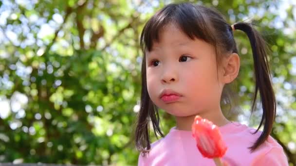 小亚洲女孩在公园吃冰淇淋 — 图库视频影像