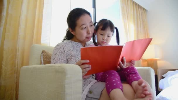 Aziatische Moeder Vertellen Van Een Verhaal Aan Haar Dochter Thuis — Stockvideo