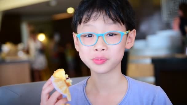 Ung Asiatisk Gutt Spiser Muffins Til Frokost – stockvideo
