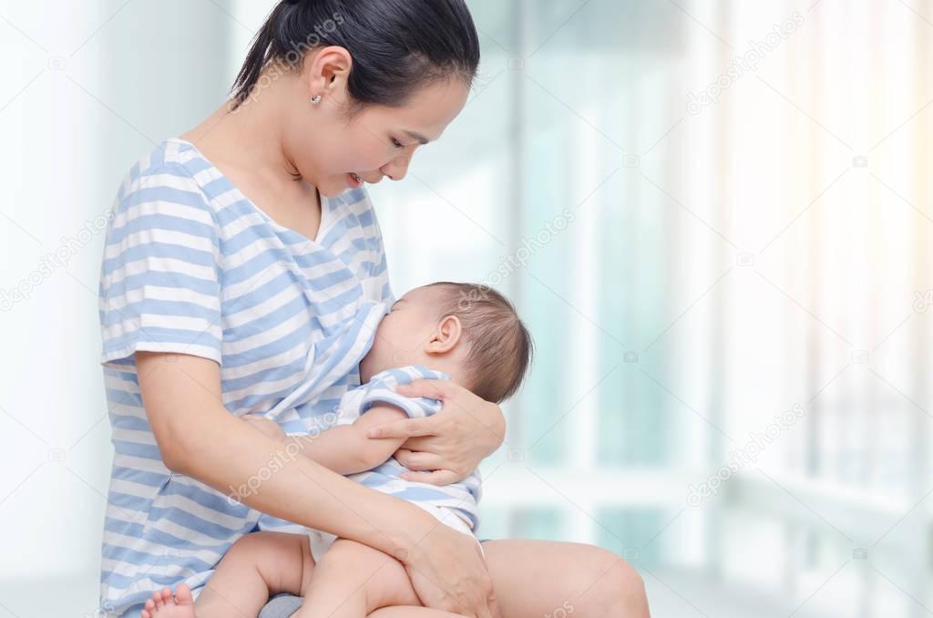 woman breast feeding to her child 