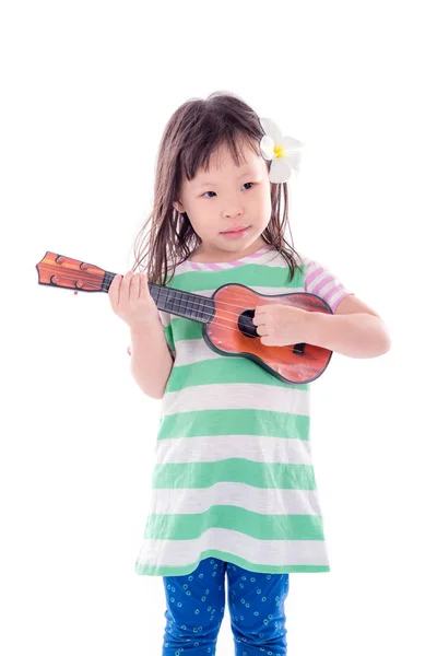 Mädchen spielt Gitarrenspielzeug auf weißem Hintergrund — Stockfoto
