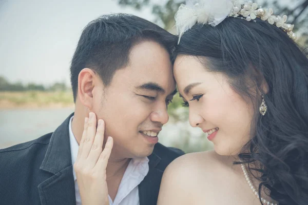 Asian bride and groom in park