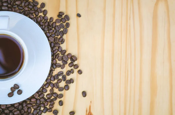 Xícara de café com grãos na mesa — Fotografia de Stock