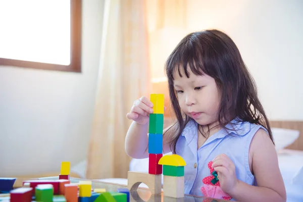Chica jugando bloque de madera en casa — Foto de Stock