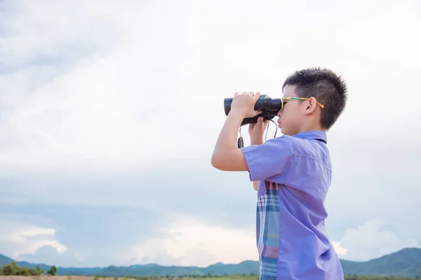 Boy watching forest via binoculars — Stock Photo, Image