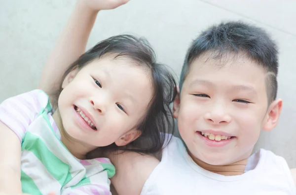 Crianças sorrindo no chão — Fotografia de Stock