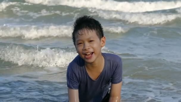 Garçon dans le surf sur une plage d'été, au ralenti — Video