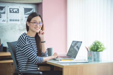 Oturma ve dizüstü bilgisayar ile çalışma güzel kadın