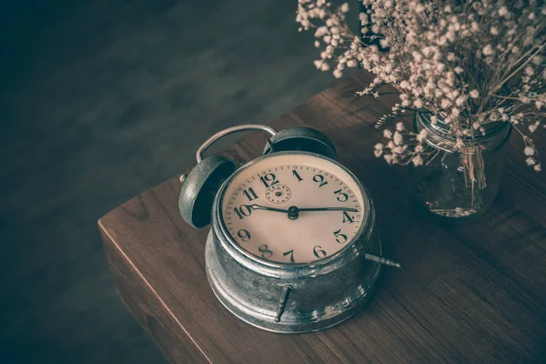 Gebroken klassieke klok op houten tafel met droge bloemenvaas — Stockfoto