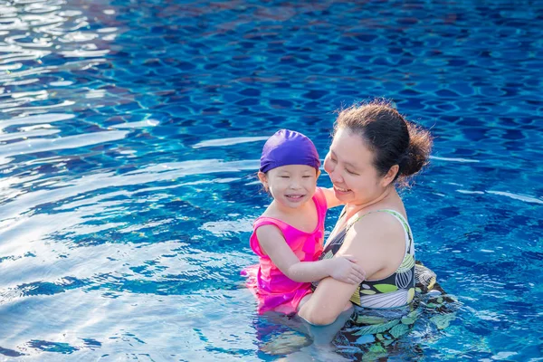 Mor och hennes dotter i poolen med ett lyckligt leende — Stockfoto