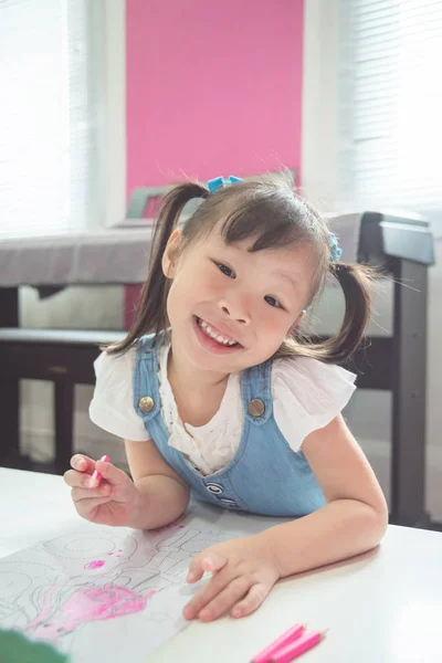 木製鉛筆で着色しながら笑みを浮かべて少女 — ストック写真