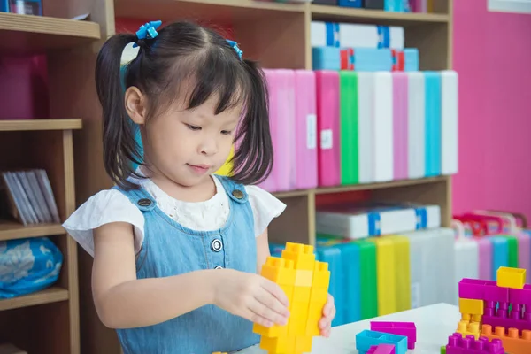 小さな女の子が保育園でプラスチック製のブロックを遊んで — ストック写真
