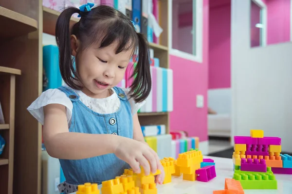Menina jogando blocos de plástico na creche — Fotografia de Stock