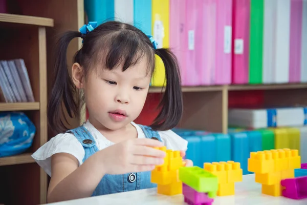 小さな女の子が保育園でプラスチック製のブロックを遊んで — ストック写真