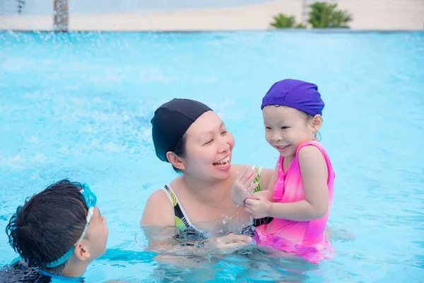 Mor och hennes barn som är glad i poolen — Stockfoto