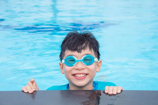 Unga asiatiska pojke klädd i blå glasögon och leende — Stockfoto