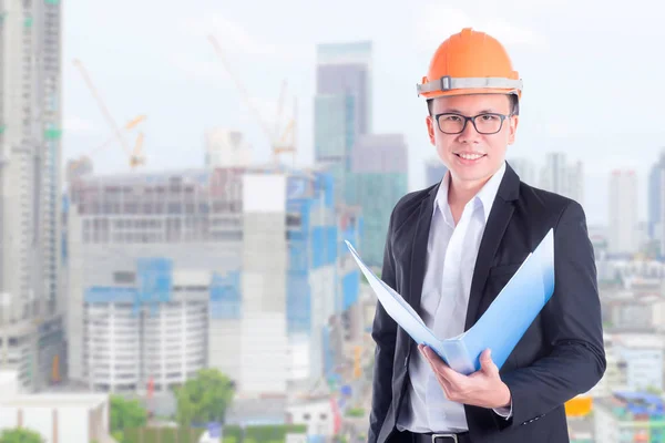 Ingeniero hombre usando casco y sonriendo en el sitio de construcción — Foto de Stock