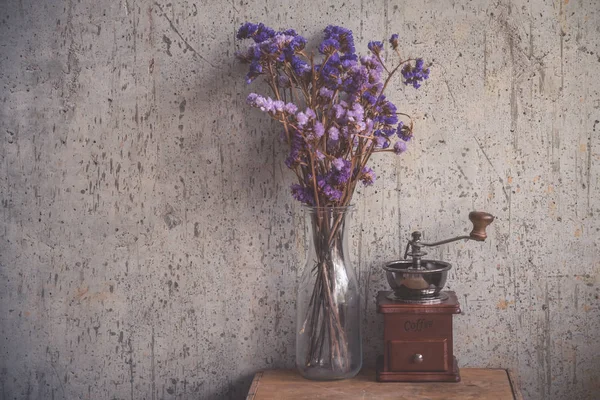 Moedor de café e vaso de flores na mesa de madeira — Fotografia de Stock