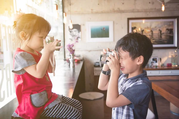 Aziatische kinderen houden van de camera en rekening houdend — Stockfoto