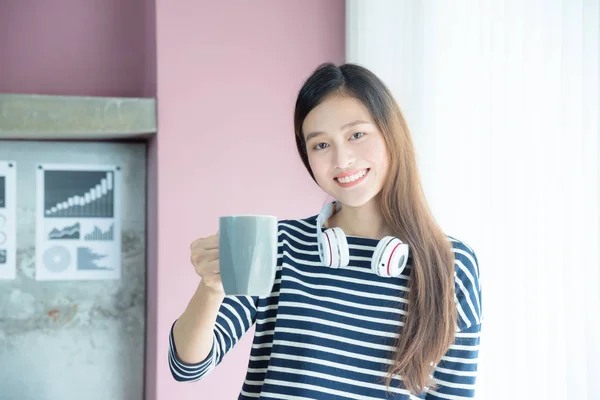 Schöne Frau trinkt Kaffee im Büro und lächelt — Stockfoto