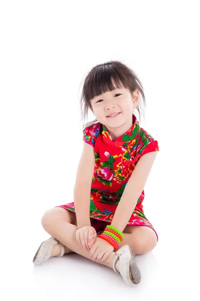 Menina vestindo vestido tradicional chinês vermelho sentado no chão — Fotografia de Stock