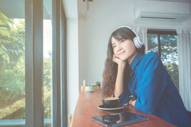 Genç kız müzik dinleme sırasında kahve içme