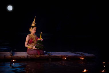 Krathong Nehri üzerinde yüzen geleneksel Tay elbiseli güzel Asyalı kız