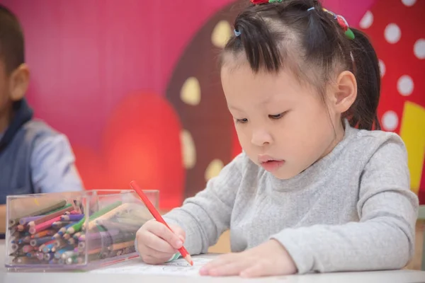 Malý preschooler Malování obrázek bt pastelky ve škole — Stock fotografie